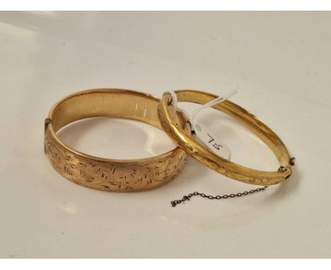A wide rolled gold bangle and a small example