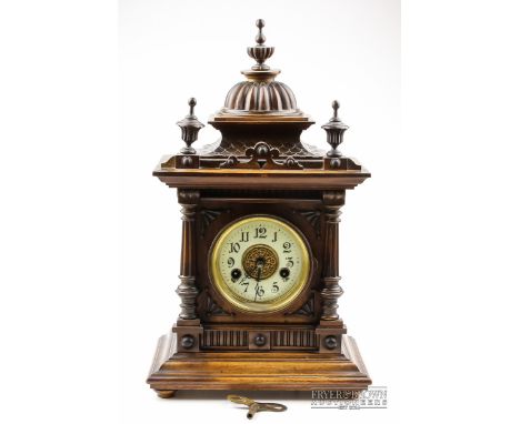 A wooden bracket clock, white enamel and gilt dial with Arabic numerals, probably American, with key and pendulum