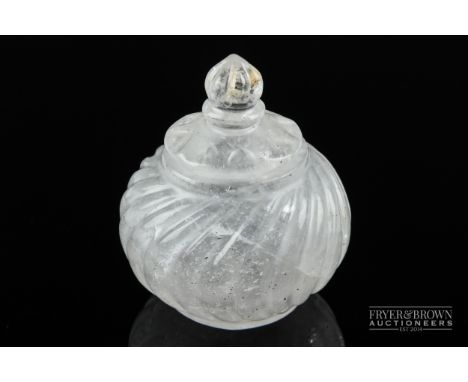 A Mughal style rock crystal perfume flask, globular, the body wrythen cut under a domed cover with bud finial, 7cm high