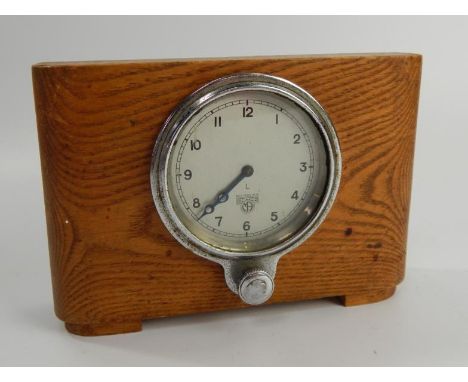 A Smiths Car clock, with chrome bezel and adjusting knob, set in an oak mantel case.