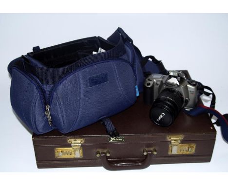 A Canon EOS3000 SLR camera,  with 28/20 lens with carrying case, and a briefcase.