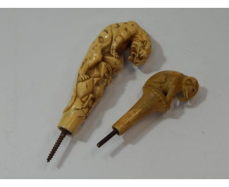 A 19thC carved ivory elephant stick or umbrella handle, and an ivorine tiger stick or umbrella handle, (2).