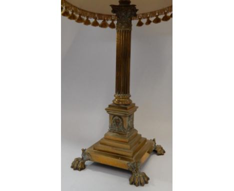 A brass Corinthian column table lamp, with stepped base and claw feet, with shade.