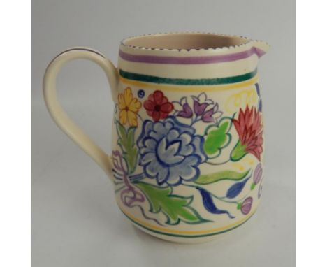 A Poole Pottery jug, decorated with sprays of flowers in polychrome hand painted decoration, 17cm high.