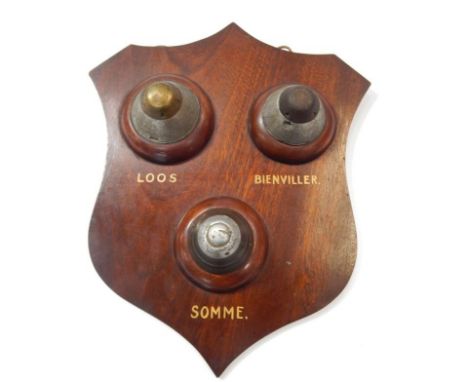 A WWI Ordnance shield, mahogany shield mounted with shell nose cones, including one with timer and inscribed beneath each con