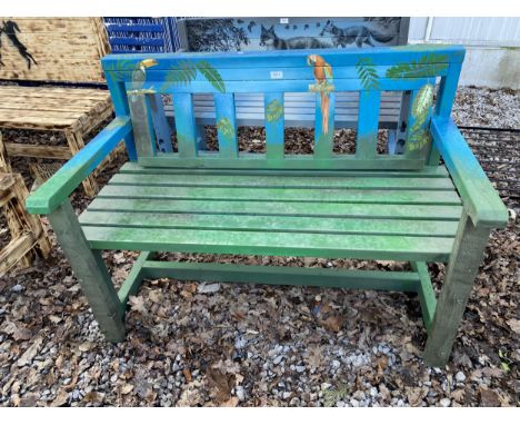 A WOODEN SLATTED GARDEN BENCH WITH PAINTED PARROT DETAIL 