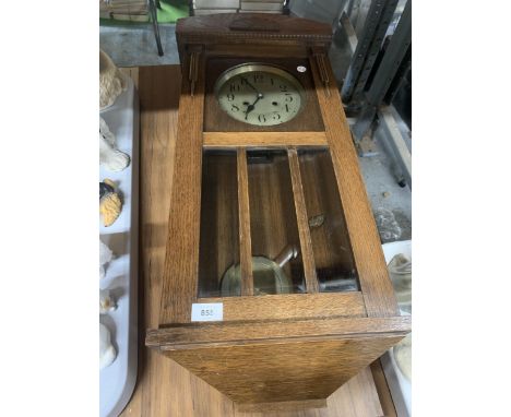 AN OAK CASED WALL CLOCK WITH PENDULUM AND KEY 