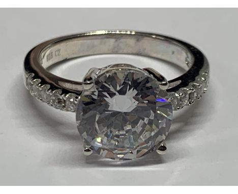 A SILVER RING WITH CUBIC ZIRCONIAS IN A PRESENTATION BOX 