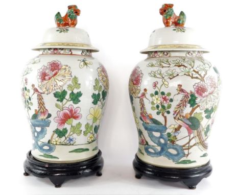 A pair of Chinese famille rose porcelain jars and covers, of baluster form, with lion dog finial, decorated in enamels with h