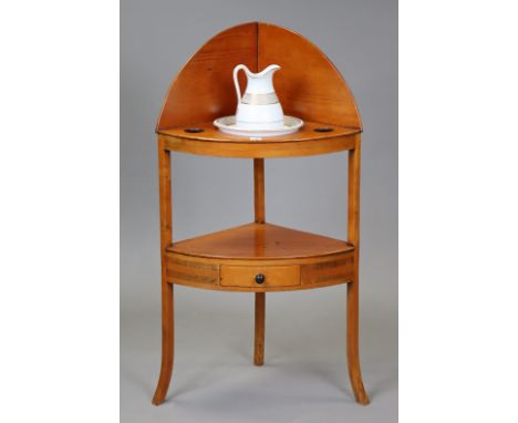 A 19th century pine bow-front two-tier corner washstand fitted with a centre drawer to the lower tier, &amp; on three shaped 