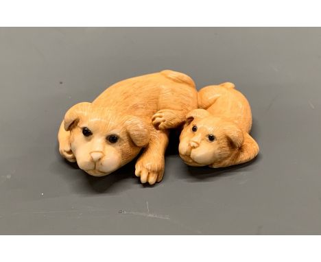 A signed Japanese carved ivory Netsuke of two dogs, W. 4.5cm.