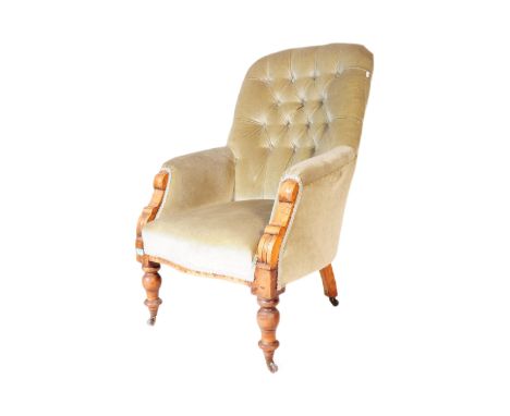 A Victorian 19th century button back armchair with turned legs, light green upholstery seat to shaped elbow rests. Measures a