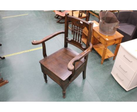 A mahogany commode with spindled back 