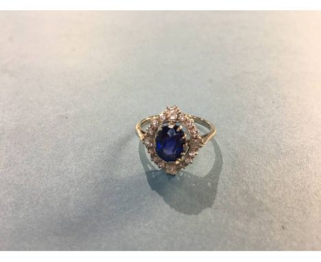 A diamond and sapphire mounted white metal ring, the central sapphire 8.1mm x 7.4mm