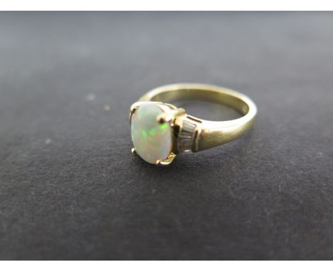 An 18ct yellow gold ring with opal set to shoulder flanked by baguette cut diamonds 5.1 grams - ring size N