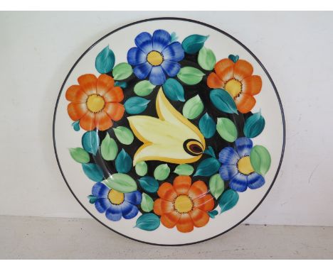 A Susie Cooper Grays Pottery floral wall plate circa 1928, central tulip on black surround by orange and blue flowers no 8145