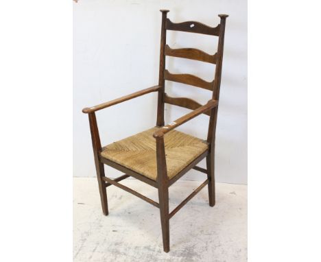 Arts and Crafts Oak Ladder Back Elbow Chair with rush seat in the manner of William Birch, 115cms high 