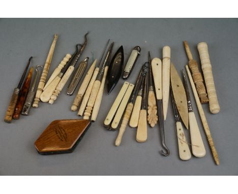 A collection of antique bone, mother of pearl and ivory boobins, shoe lace hooks and needle cases. 