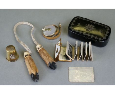 An antique black lacquered paper mâché snuff box together with a thimble, miniature tape measure and a novelty miniature book