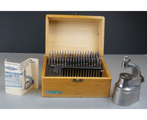 A wooden cased watch repair riveting and staking tool set. 