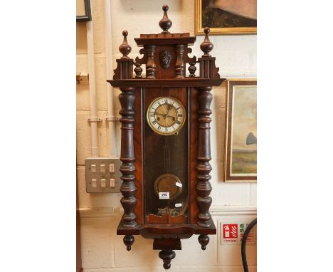 A vintage ornate wooden cased chiming wall clock with pendulum movement, complete with key. 