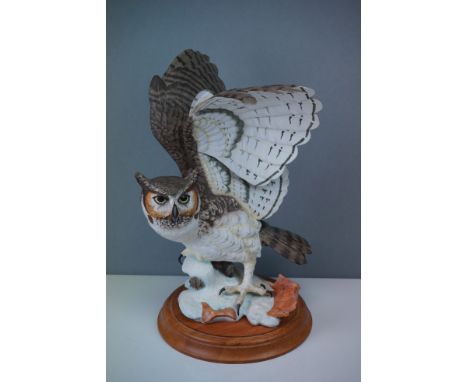 A Franklin Mint hand painted porcelain Great Horned owl on wooden plinth. 