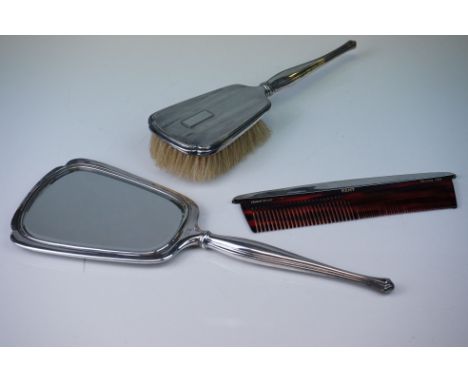 A sterling silver engine turned decorated mirror, brush and comb set. 