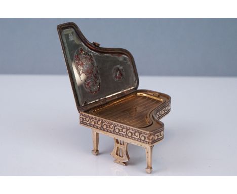 A vintage Pygmalion Compact in the form of a piano. 