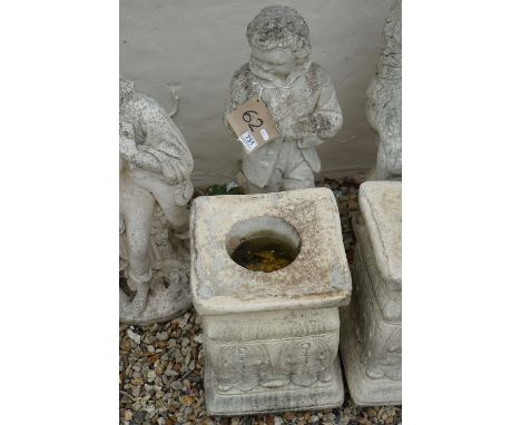 A garden statue of a boy standing by a fire, on separate plinth, approx 1m 16cm in height. 