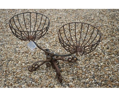 A vintage wrought iron twin planting baskets on four scrolled supports, baskets are approx 37cm, length 85cm and approx 46cm 
