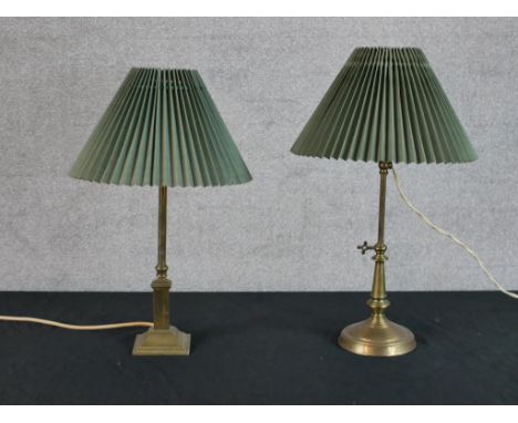 An early 20th century adjustable brass table lamp raised on circular foot, together with a brass table lamp raised on square 