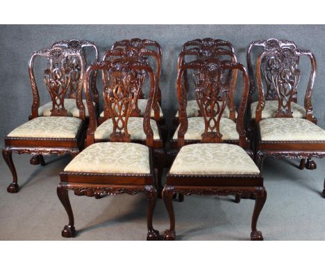 A set of ten Chippendale style mahogany dining chairs, with ornately detailed pierced splat backs, over ivory damask drop in 