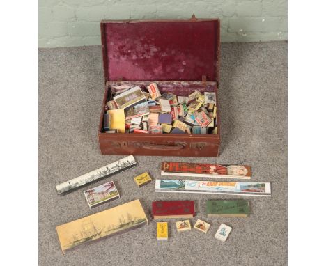 A vintage leather suitcase containing a quantity of matchboxes to include Swan Vestas, tourist examples, Bryant &amp; May's, 