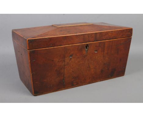A walnut tea caddy of sarcophagus form; the hinged lid revealing three sections, for restoration. Width: 30cm.  Split to the 