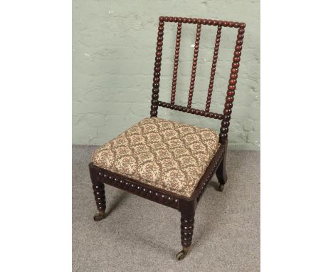 A Victorian bobbin turned nursing chair with upholstered seat  