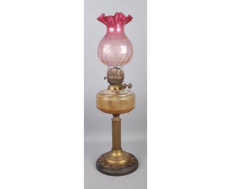 A early Twentieth Century 'British Made' oil lamp, featuring cylindrical Corinthian column, glass reservoir and frosted pink 