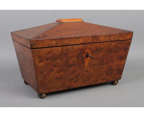 A burr walnut two-section tea caddy of sarcophagus form, raised on small bun feet. With key. Width: 23.5cm.  Right section li