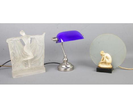 Three assorted table lamps, to include desk lamp with blue shade and art deco style crouching woman in front of a frosted cir
