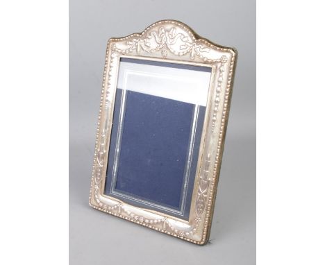 A silver mounted photo frame featuring sash decoration. Approx. internal photo dimensions 12cm x 17cm. Hallmarked Sheffield 1