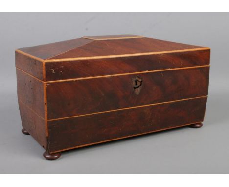 A mahogany tea caddy of sarcophagus form, with two sections and circular hole for tea bowl. Width: 29cm.  Bowl and handles mi