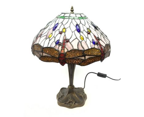 Tiffany style table lamp, with cast spreading base detailed with flowers, and leaded glass shade detailed with dragonflies, o