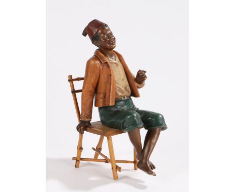 Bloc pottery figure, depicting a gentleman wearing a red fez, seated in a bamboo chair, the figure stamped BB 4733 to base, 2