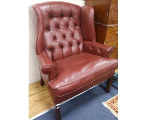 A leather button back wing armchair