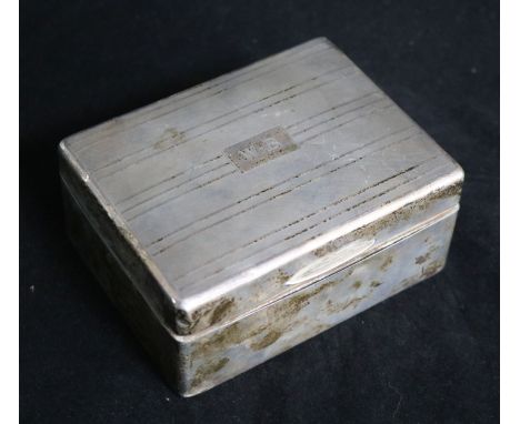 A silver engine-turned cigarette box, with initials to cover.