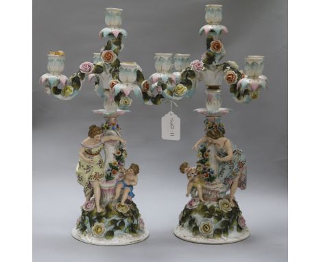 A pair of Sitzendorf figural and flower-encrusted four-branch five-light candelabra