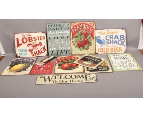 A collection of reproduction enamel signs including three continental style advertising examples.