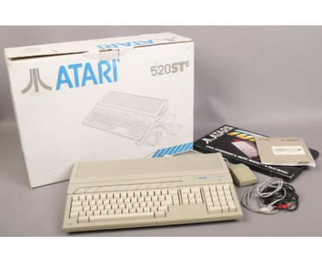 A boxed Atari 520 STE with instruction manual and accessories.