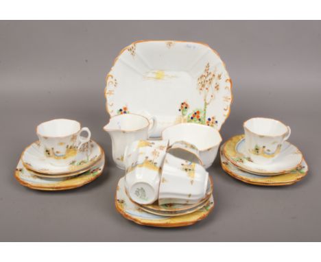 A Melba bone china Art Deco six place teaset, printed and enamelled with romantic landscapes.