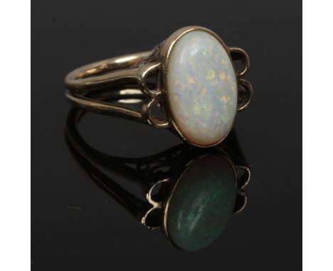 A vintage 9ct gold opal ring set with a large ovoid stone on split shoulders, N 1/2.