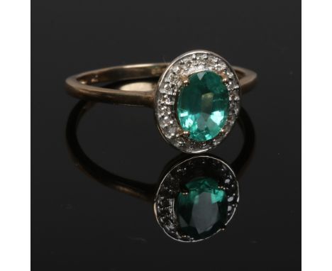 A 9ct gold dress ring, set with a faceted green gemstone under a border of diamonds, size S.